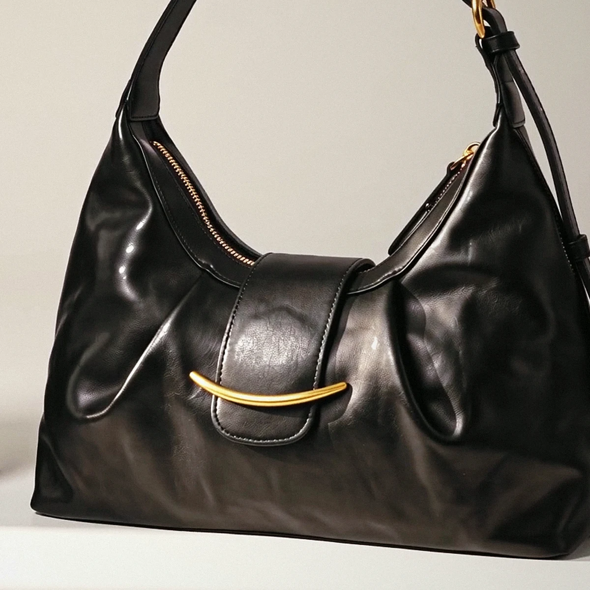 Gold hardware and zip on the small black leather bag