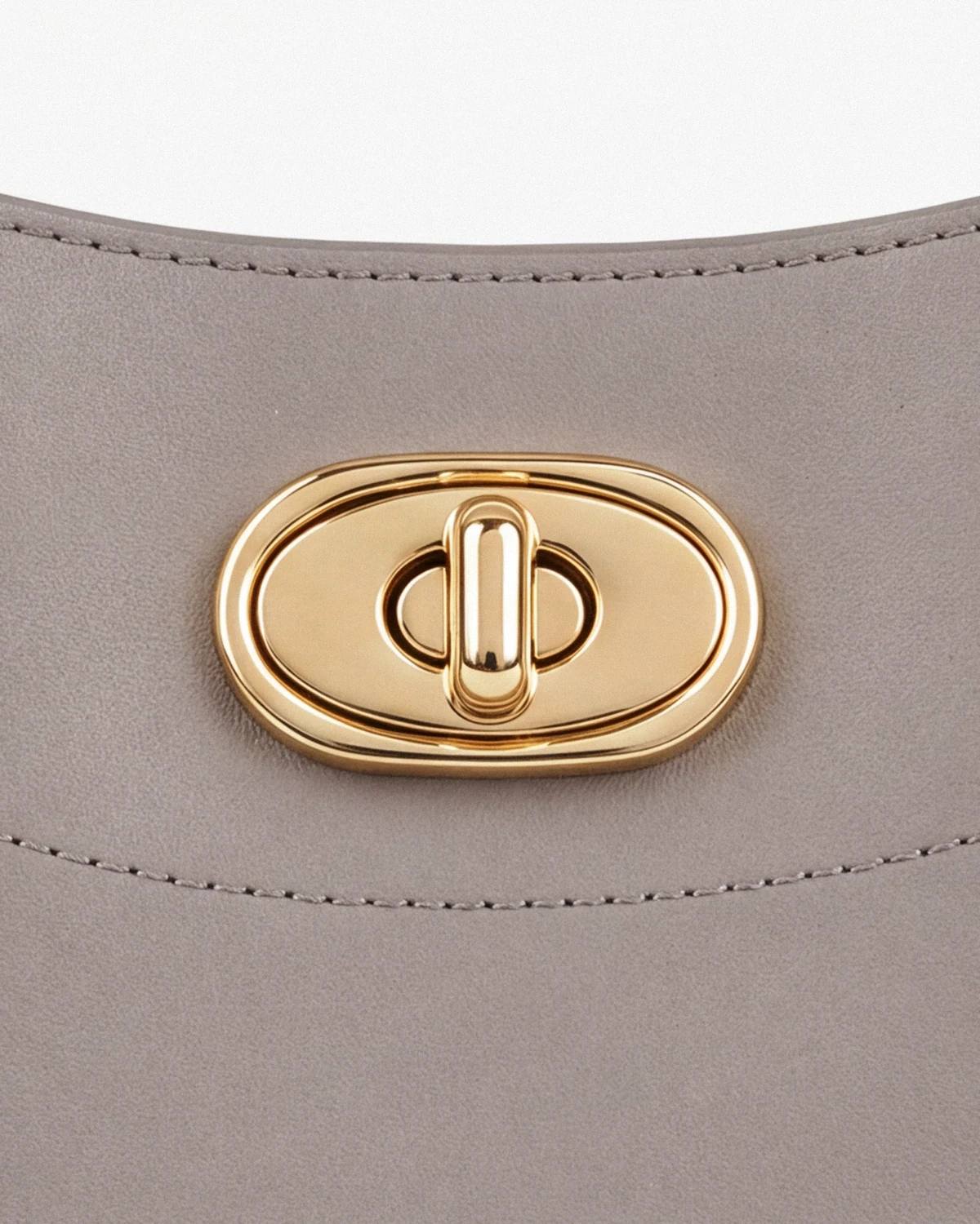Gold turn-lock on the gray leather top-handle bag